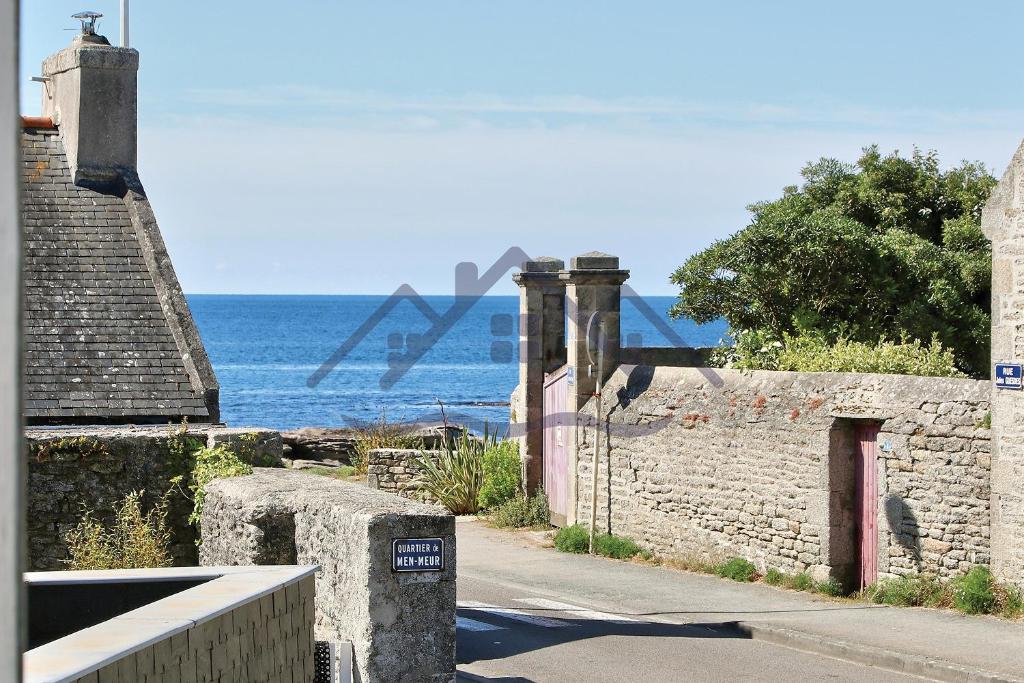 吉尔维内克LocaLise - M3A La Maison du pêcheur au Guilvinec - Chambres vue mer - A 20m de la mer située à la pointe de Men Meur - Tout à pied, plage, port, centre, commerces, marché - Wifi inclus - Linge de lit inclus - Jardin clos - En option , ménage et serviettes的底部有海洋的石墙