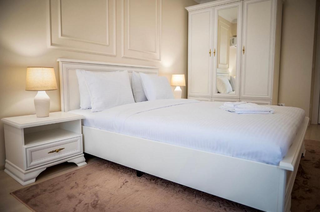 康斯坦察Apartament Zafi Lakeview的白色的卧室配有一张白色的大床和镜子