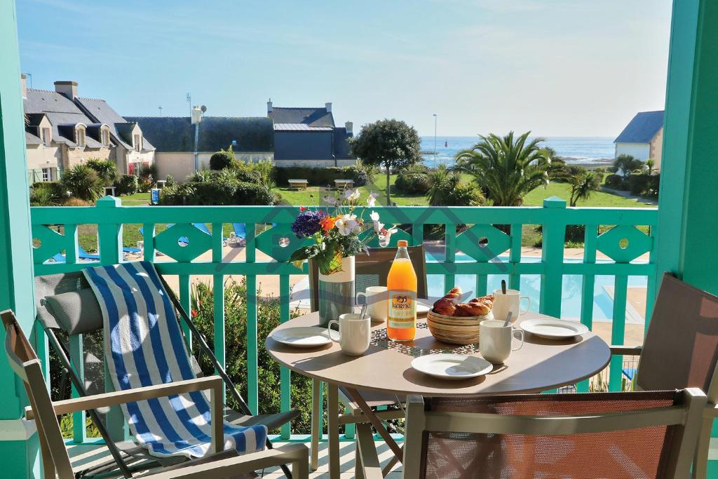 吉尔维内克LocaLise au Guilvinec - A15 - Vue sur la mer la piscine et le jardin - Tout à pied, plages, port, centre, commerces, marché - Wifi inclus - Animaux bienvenus - Linge de lit inclus的海景阳台上的桌子