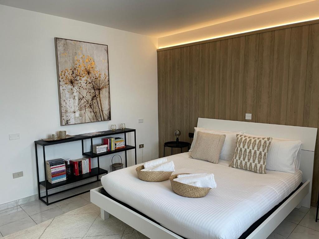 乌尔巴尼亚Casa Monte Santo的一间卧室配有一张大白色床,上面有两个篮子