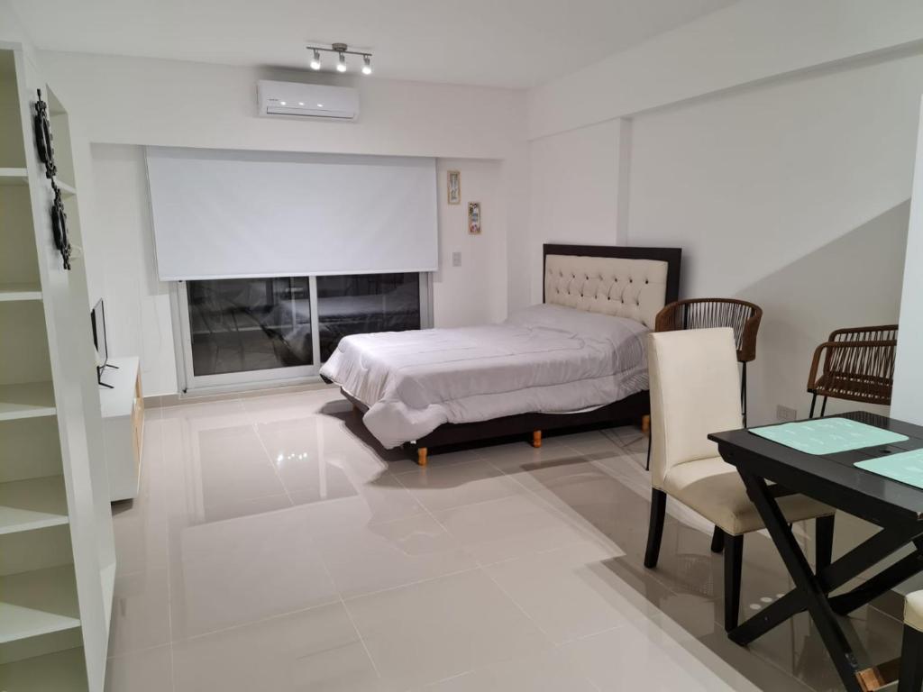 布宜诺斯艾利斯Paseo De La Cisterna UF 320的一间卧室配有一张床、一张桌子和一个窗户。