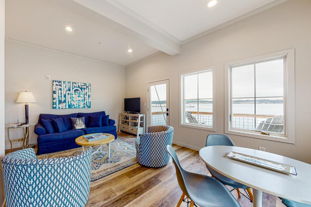 库珀维尔Penn Cove Strand #F的客厅配有蓝色的沙发、桌子和椅子