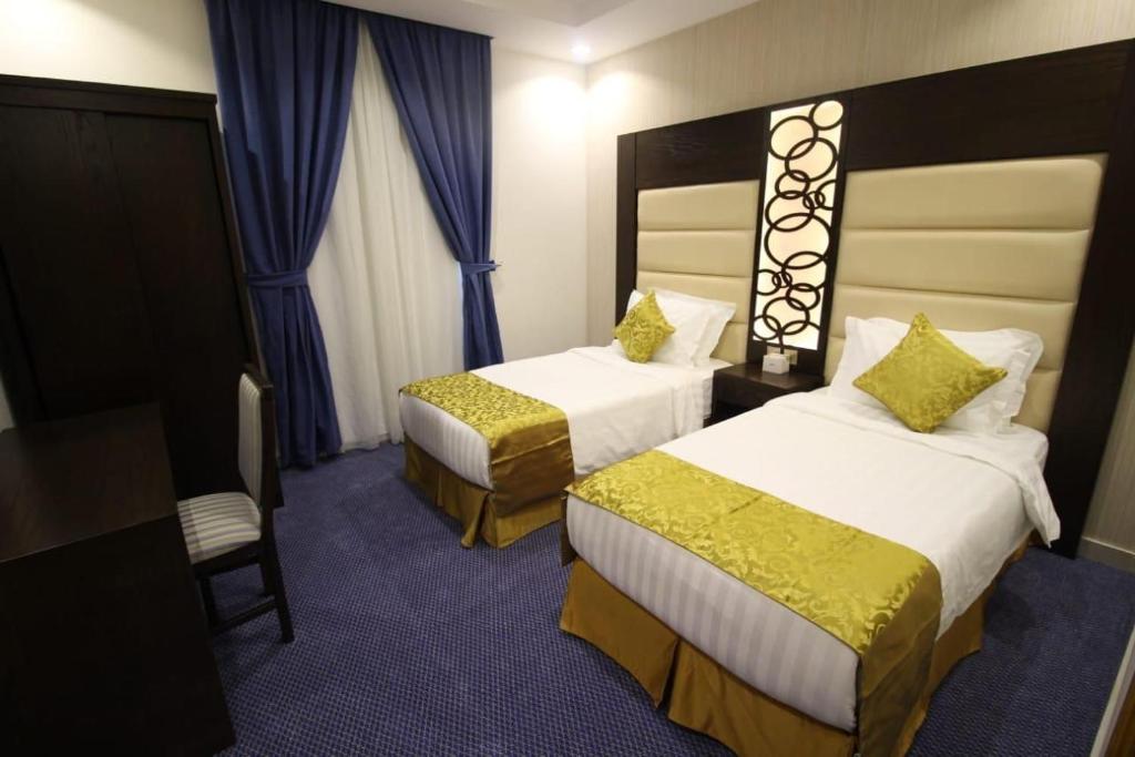 塔伊夫السهم الذهبي للشقق المخدومة的酒店客房,配有两张床和椅子