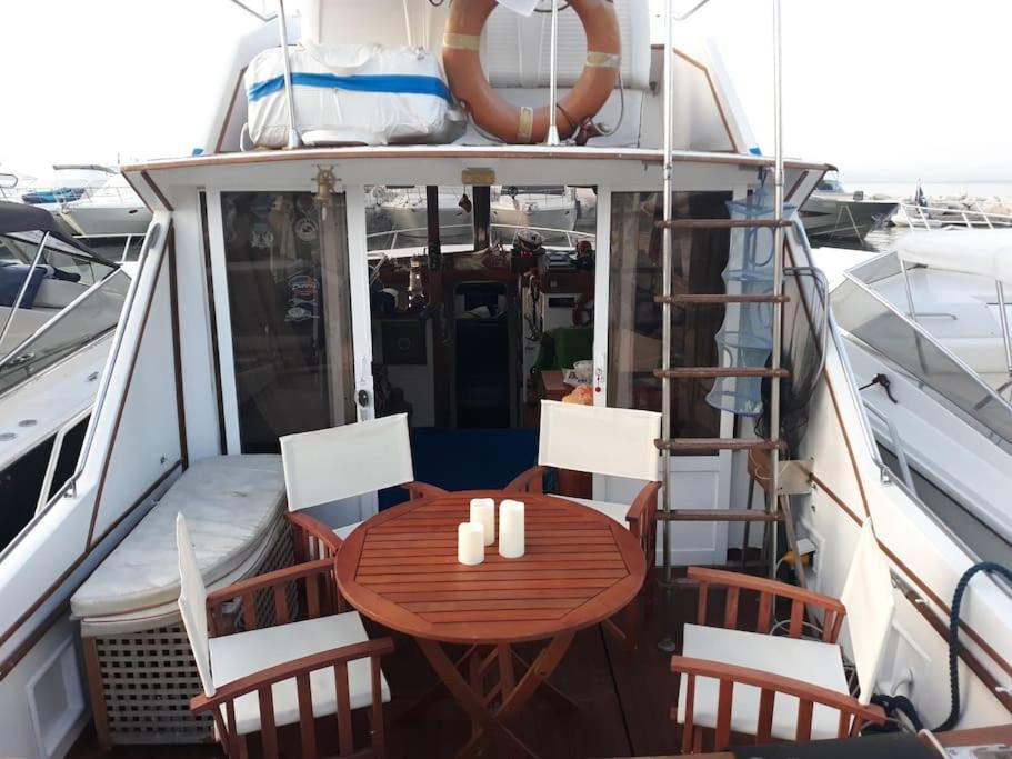伊斯基亚Barca deliziosa的船上的一张木桌和椅子