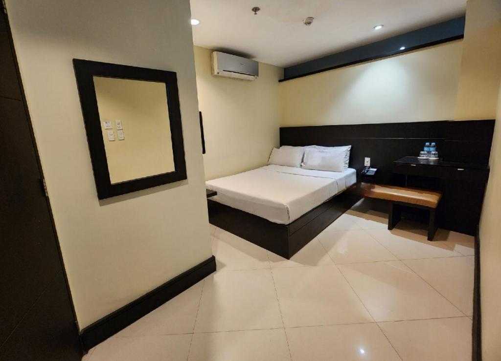 卡兰巴Green Glass Hotel的一间小卧室,配有一张床和镜子