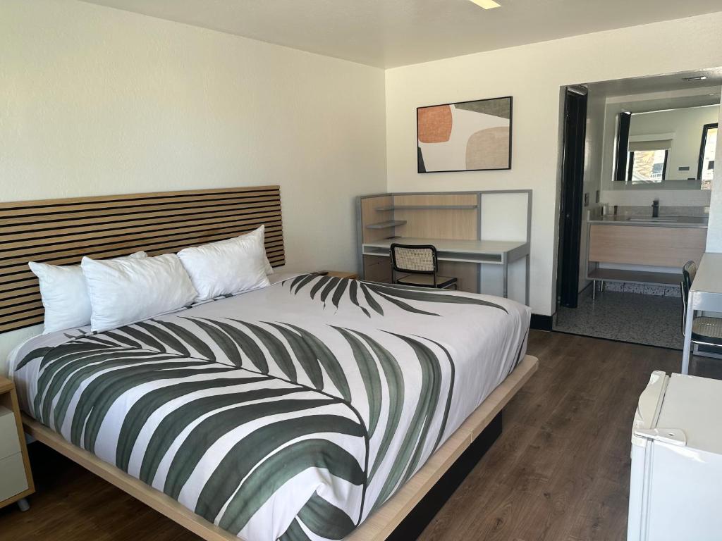 哈瓦苏湖城Sway Hotel的一间卧室配有一张大床、一张桌子和一把椅子