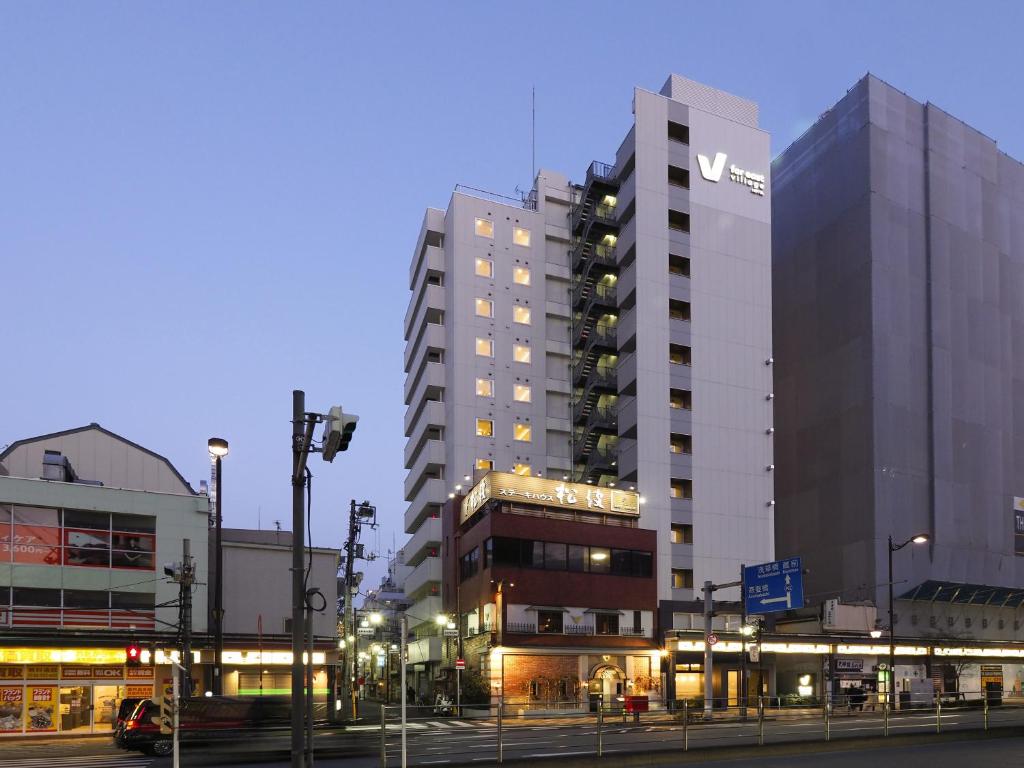 东京Far East Village Hotel Tokyo, Asakusa的一座高大的建筑,旁边有一个标志