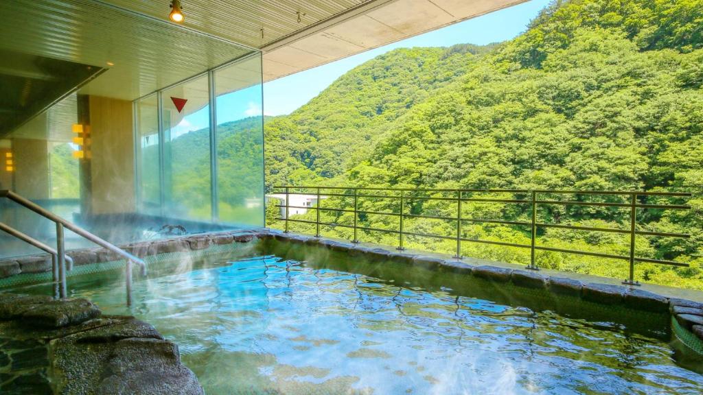 会津若松Ooedo Onsen Monogatari Higashiyama Grand Hotel的山景热水浴池