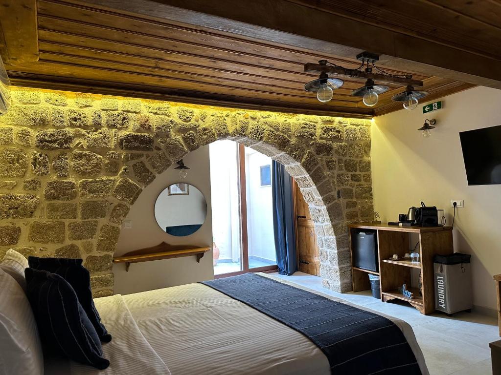 罗德镇Midgard Suites (Medieval Town)的一间卧室设有石墙和床