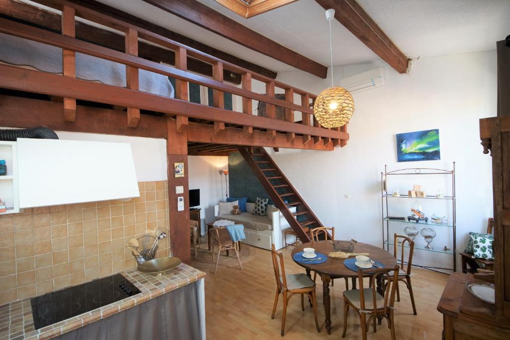 卡西斯Appartement le Mehari的厨房和带螺旋楼梯的客厅