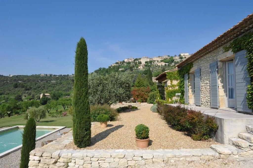 戈尔德In Gordes, facing the entire Luberon Park a beautiful 5 bedrooms house的一座花园,花园内有房子和树