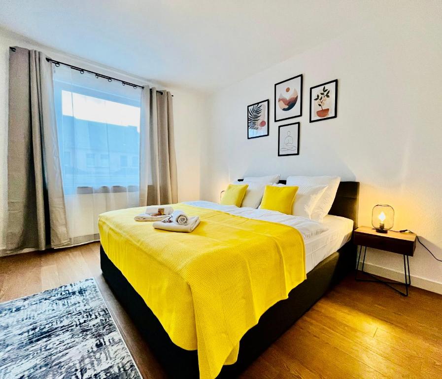 科布伦茨BIG-6-Guests-Kingsize-Netflix-Badewanne-Hauptbahnhof-Zentral的一间卧室配有一张带黄色毯子的大床