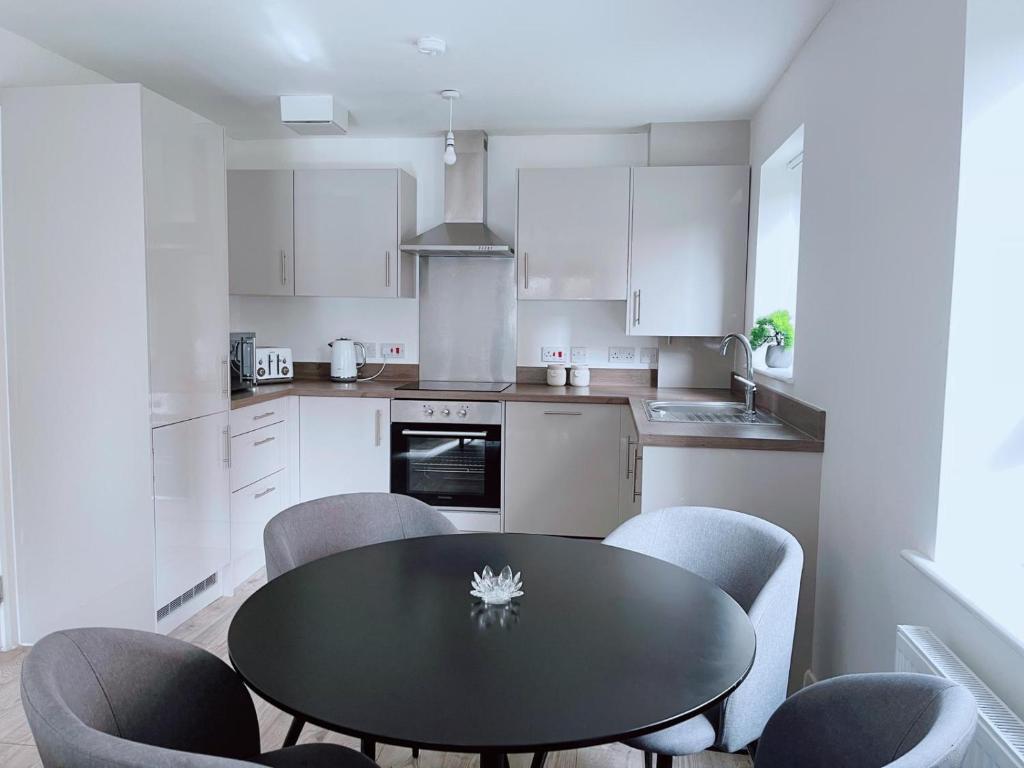 曼彻斯特Shared Modern Apartment Double Bedroom With Attached Bath的厨房配有黑色的桌子和椅子