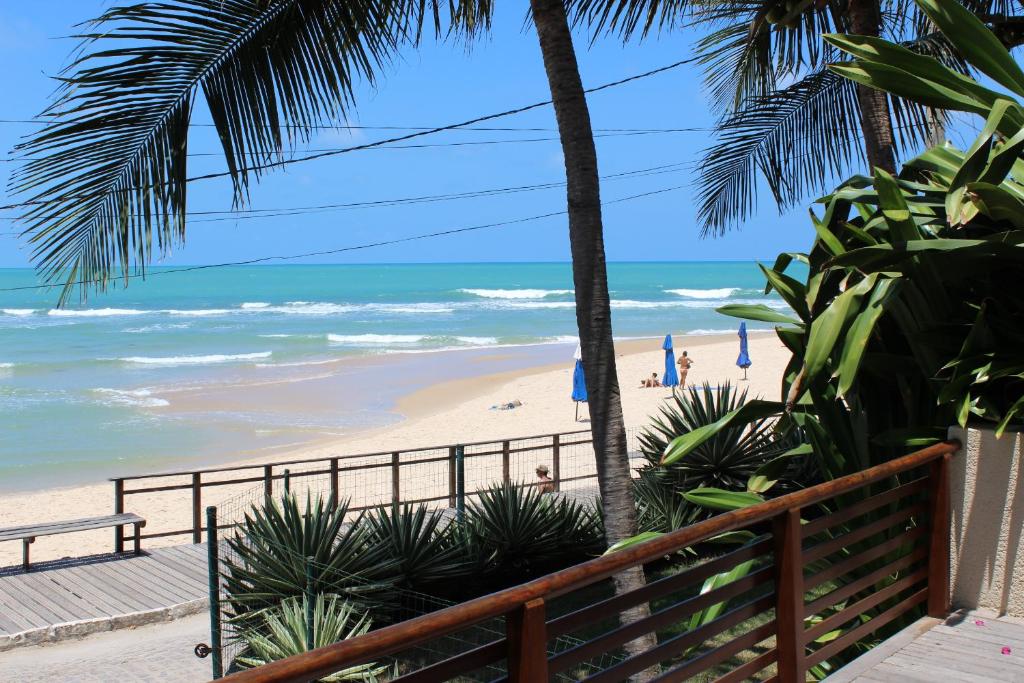 皮帕Casa Surucuá com localização espetacular frente à Praia do Centro de Pipa - 2 a 4 quartos suite的从度假村的阳台上可欣赏到海滩景色