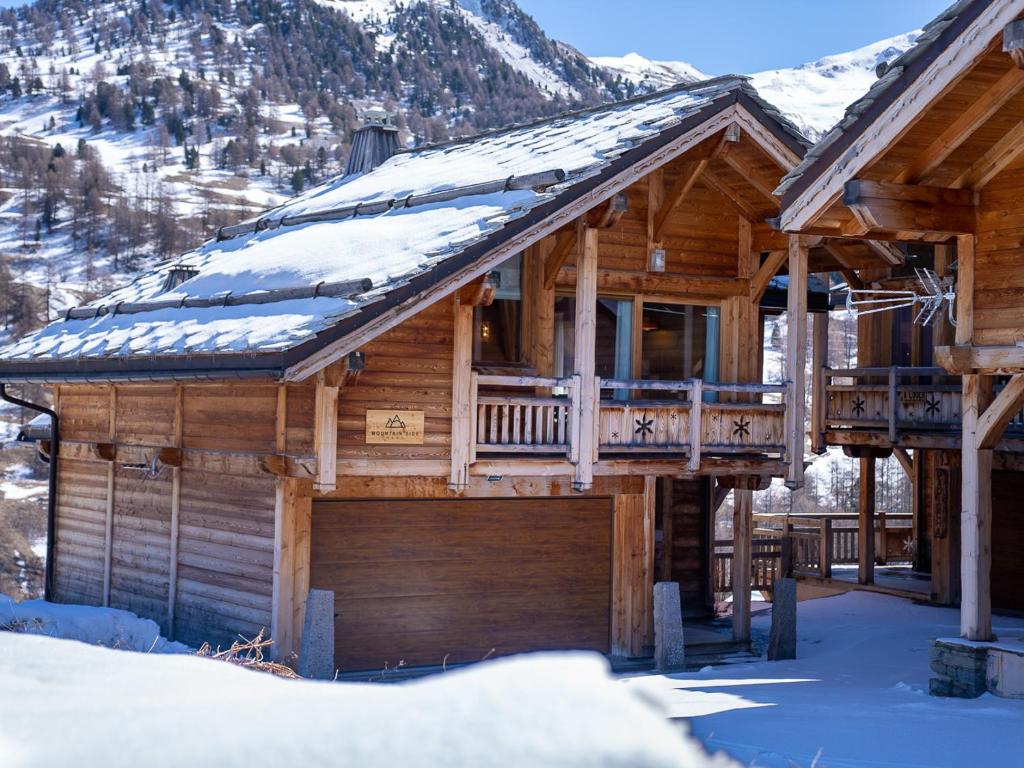 瓦尔Chalet Mountainside avec sauna et jacuzzi à 200m des pistes的小木屋,屋顶上积雪