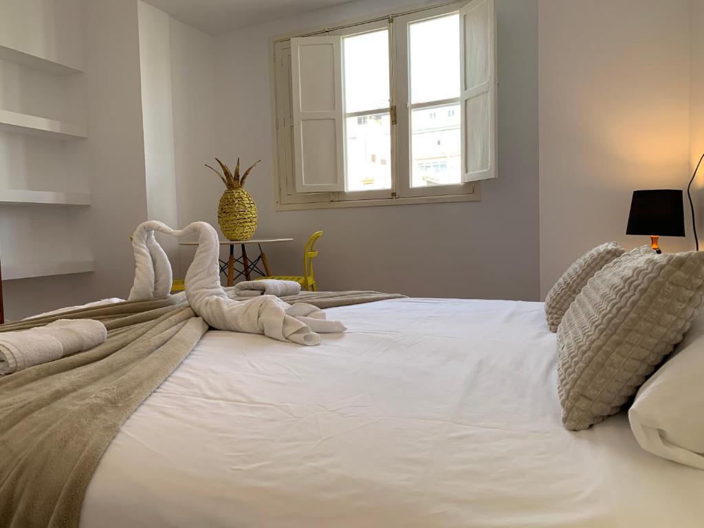 大加那利岛拉斯帕尔马斯Doranda Rooms Las Canteras的一张白色的大床,上面有毛巾动物