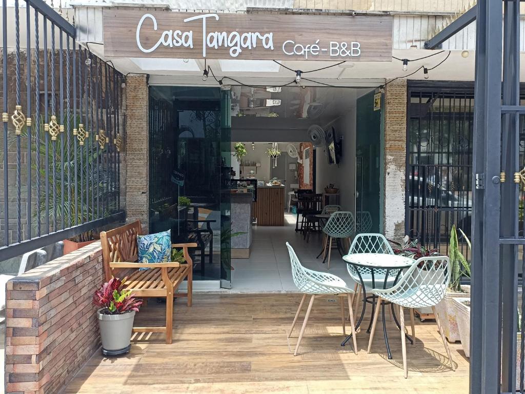 麦德林Casa Tangara Café y Hospedaje的庭院里设有桌椅的咖啡厅