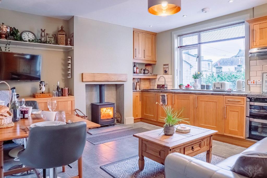 邓布兰Cottage Apartment的厨房以及带桌子和壁炉的客厅。