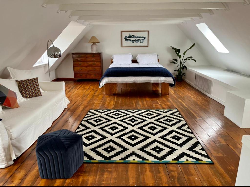 都柏林Charming central 3 Bed的一间卧室配有床、沙发和地毯。