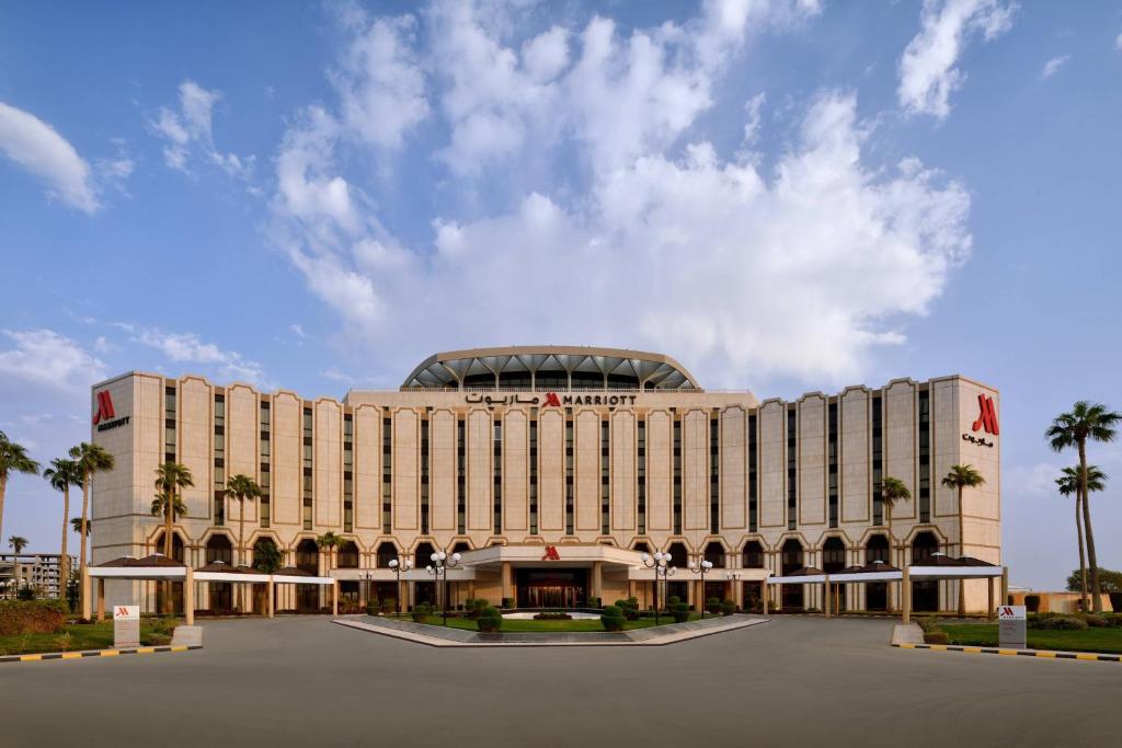 利雅德万豪酒店利雅得机场店的一座棕榈树环绕的大建筑