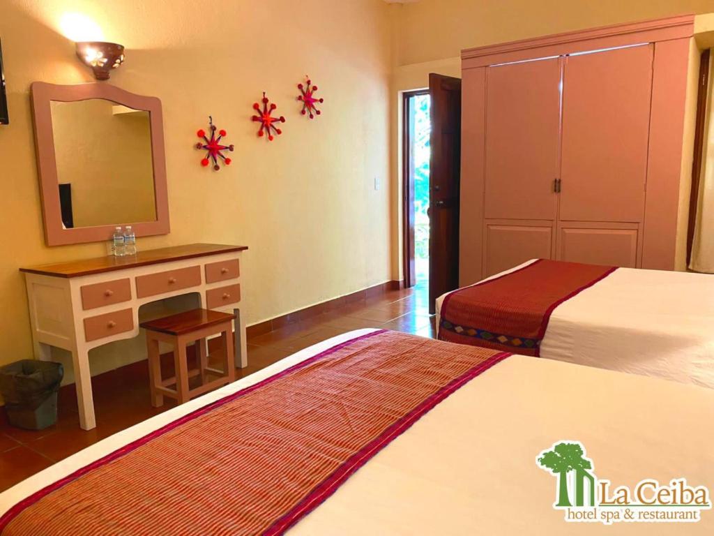 恰帕德科尔索拉塞瓦酒店的一间卧室配有两张床、一个梳妆台和镜子