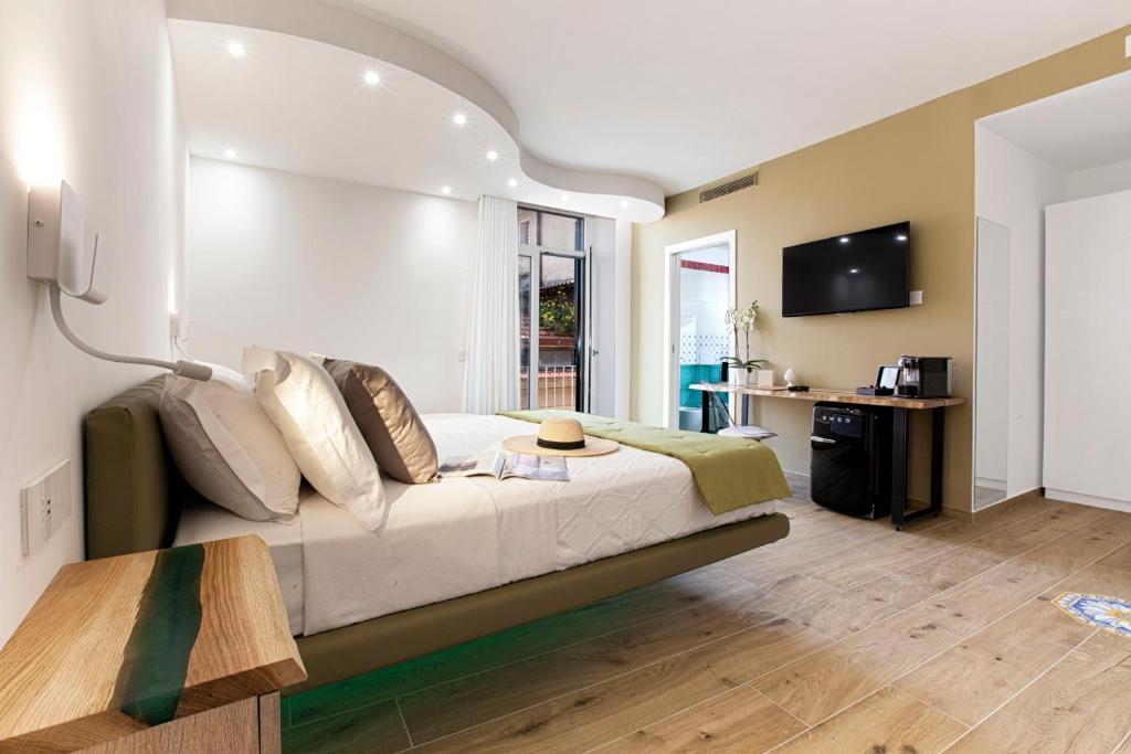 索伦托YourHome - Lidia Rooms & Suites的一间卧室配有一张大床和电视