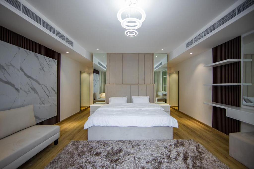 八田Jeema lodge的卧室配有一张白色的大床和一张沙发。