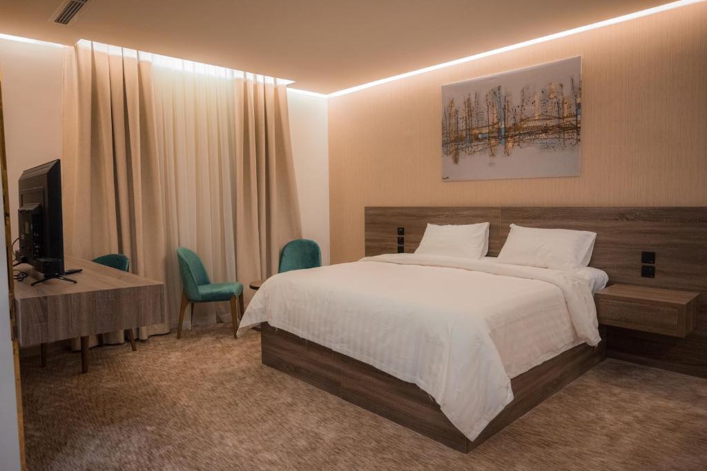 麦地那فندق بلاتينيوم الاولي الفندقية的一间卧室配有一张床、一张书桌和一台电视
