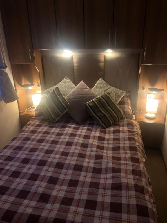 桑当First Steps Caravan Rentals的一张带两个枕头的床和两个灯