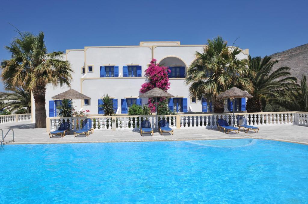 佩里沃罗Nikolas Villas的大楼前设有游泳池的酒店