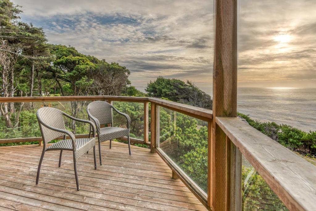 新港The Lookout的两把椅子位于俯瞰着大海的房子的甲板上