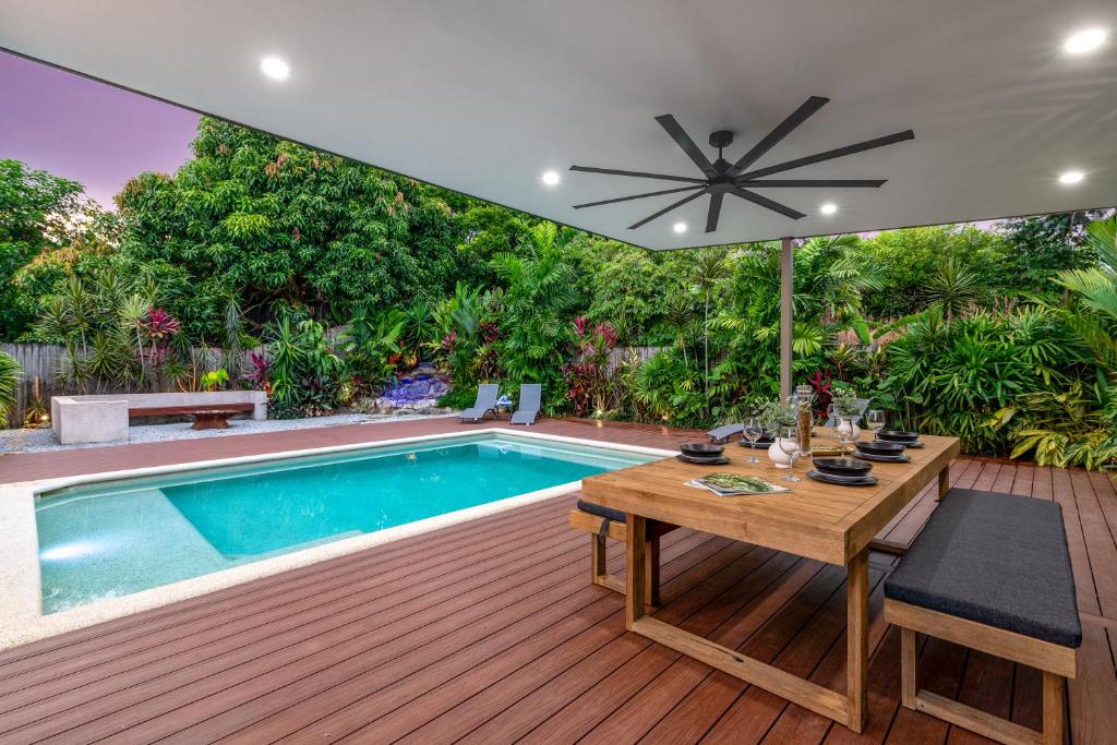 道格拉斯港Paradiso的一个带桌子和遮阳伞的庭院和一个游泳池