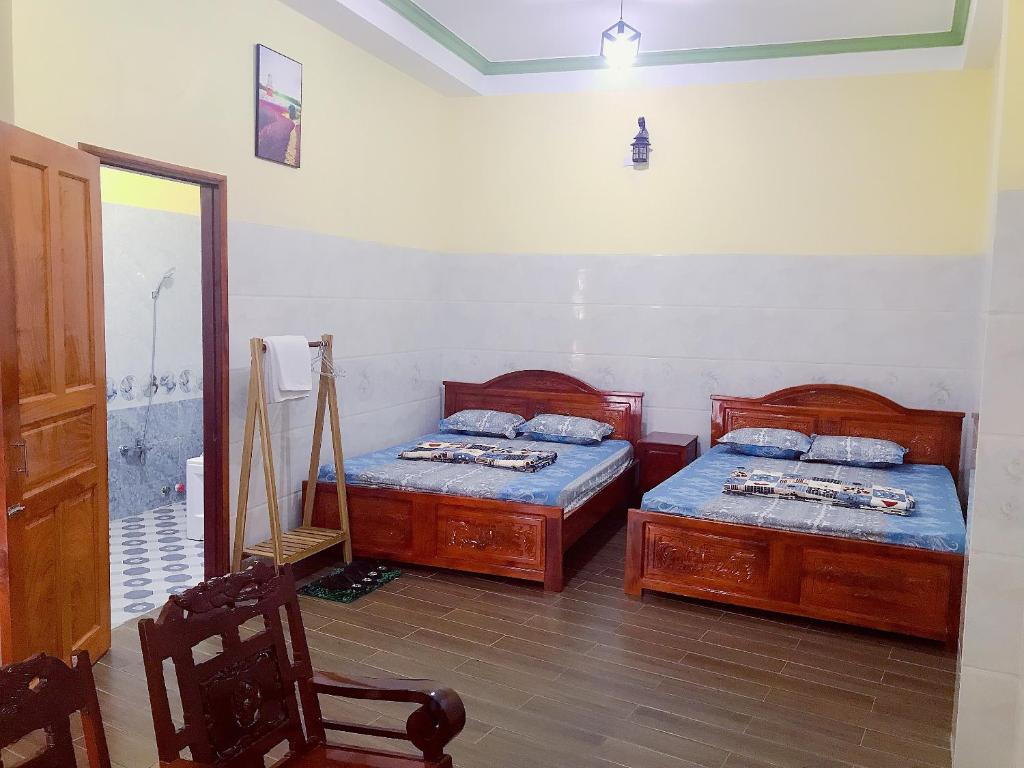 Bến LứcKhách sạn Thanh Bình Bến Lức的一间卧室设有两张单人床和一面镜子