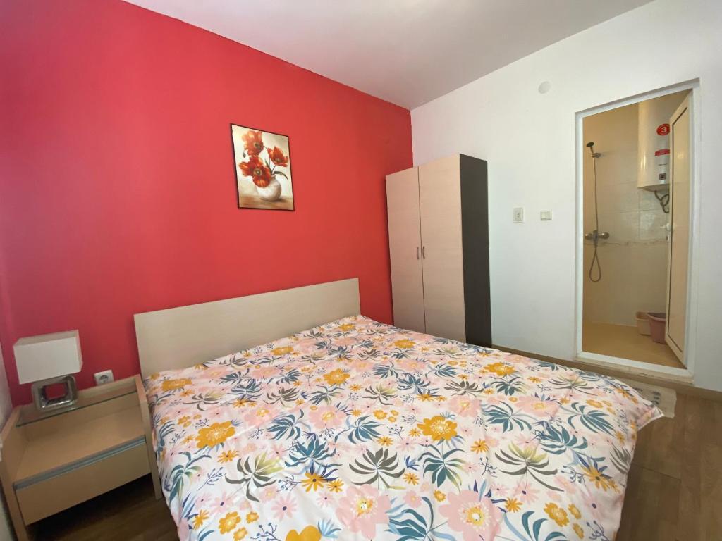 阳光海滩VIOLET GARDEN 2 Veranda Apartment的一间卧室设有一张床和红色的墙壁
