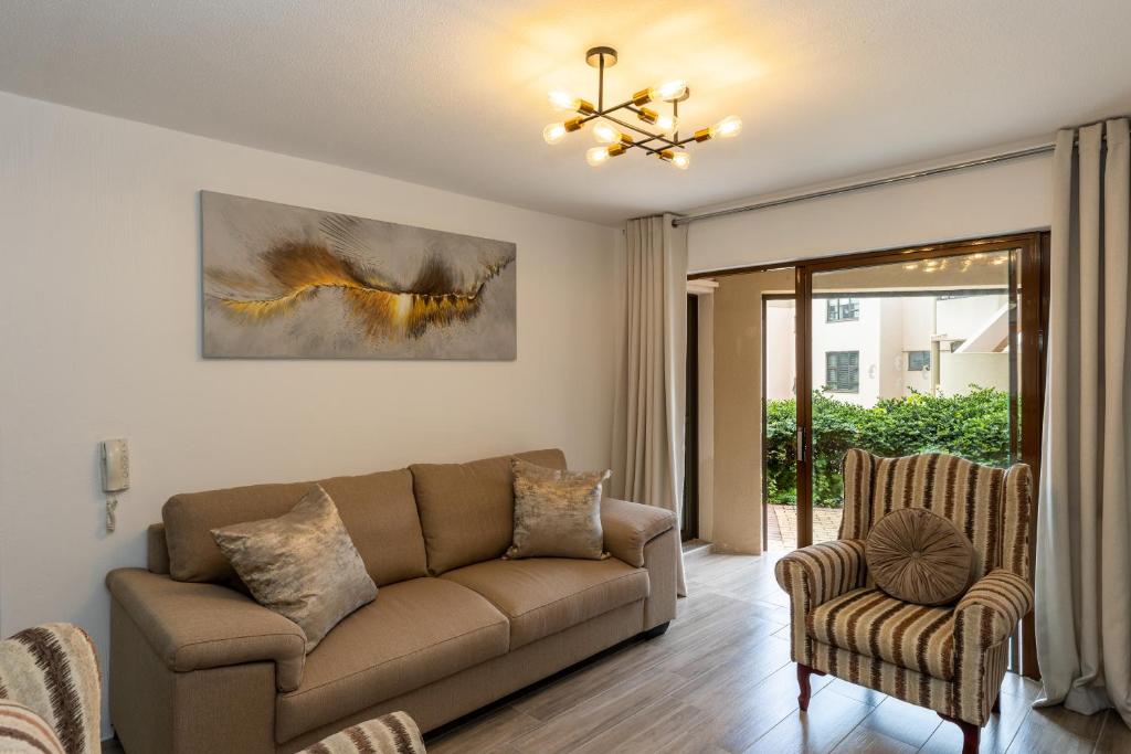德班67 The Shades - Luxury Apartment in Umhlanga - Airconditioning throughout and Inverter的客厅配有沙发和两把椅子