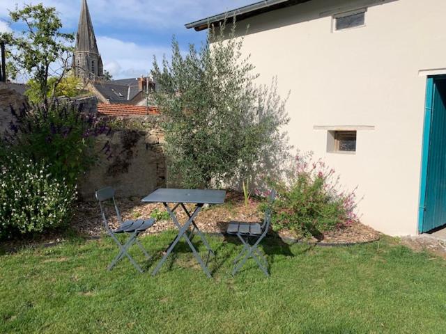 南特Chambre d'Hôtes Les Petits Oiseaux的院子里的一张野餐桌和两把椅子