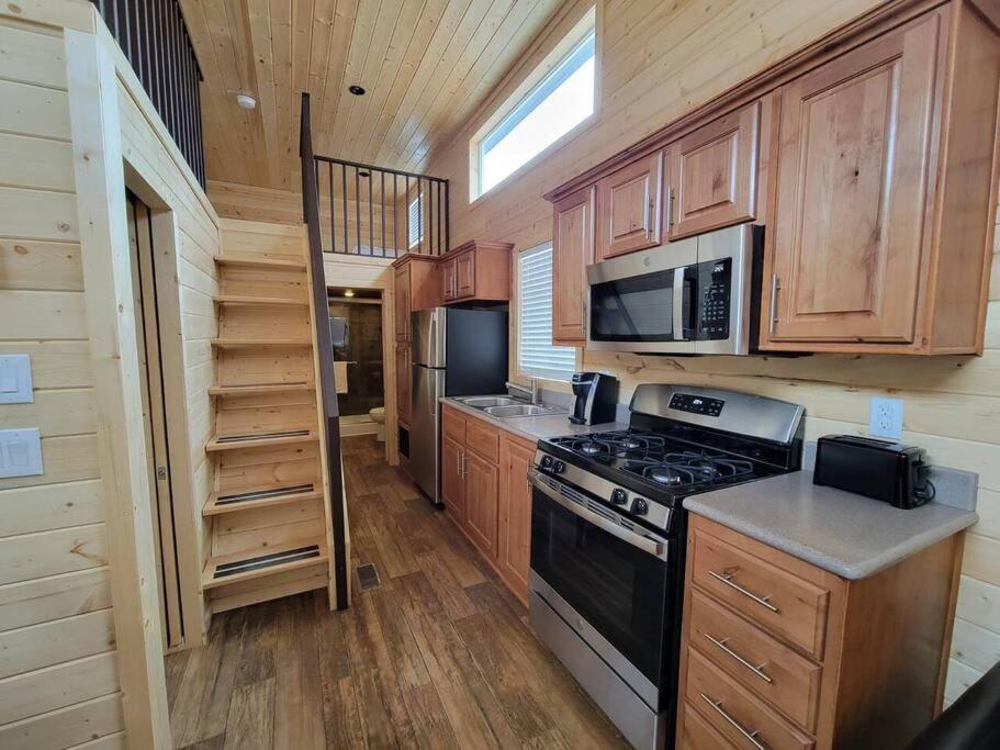瓦莱036 Tiny Home nr Grand Canyon South Rim Sleeps 8的厨房配有木制橱柜、炉灶和微波炉。