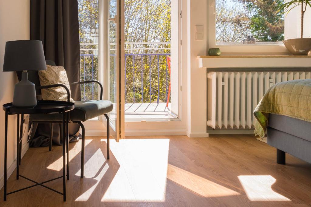 波鸿FeelsLikeHome - Traumhafte zentrumsnahe Wohnung mit Balkon&Parkplatz的卧室配有床、椅子和窗户。