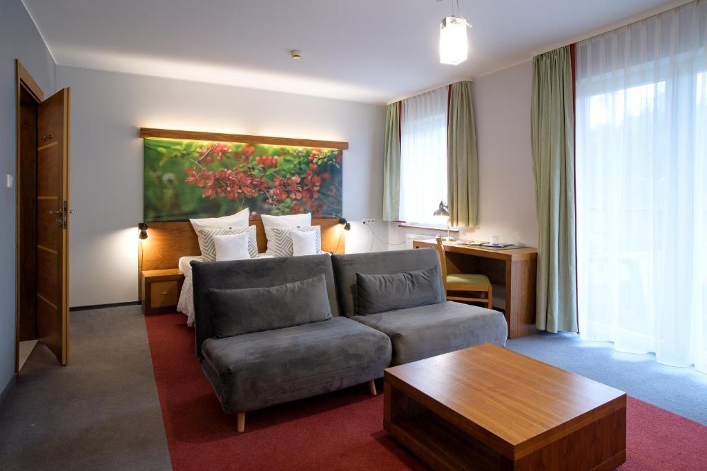 科希切日纳Hotel Szarlota - Kompleksowo na Kaszubach的客厅配有沙发和桌子