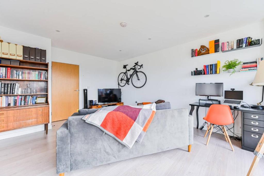 伦敦2-Bed Apartment only 15 mins from Central London的一间带沙发的卧室和一张带自行车的桌子