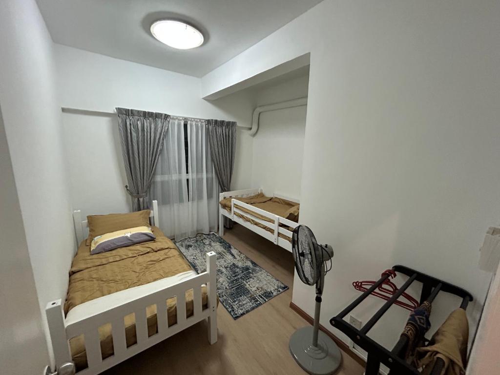 Kampong Bukit DaratHanizz Vacation Home的一间带两张床和风扇的小卧室