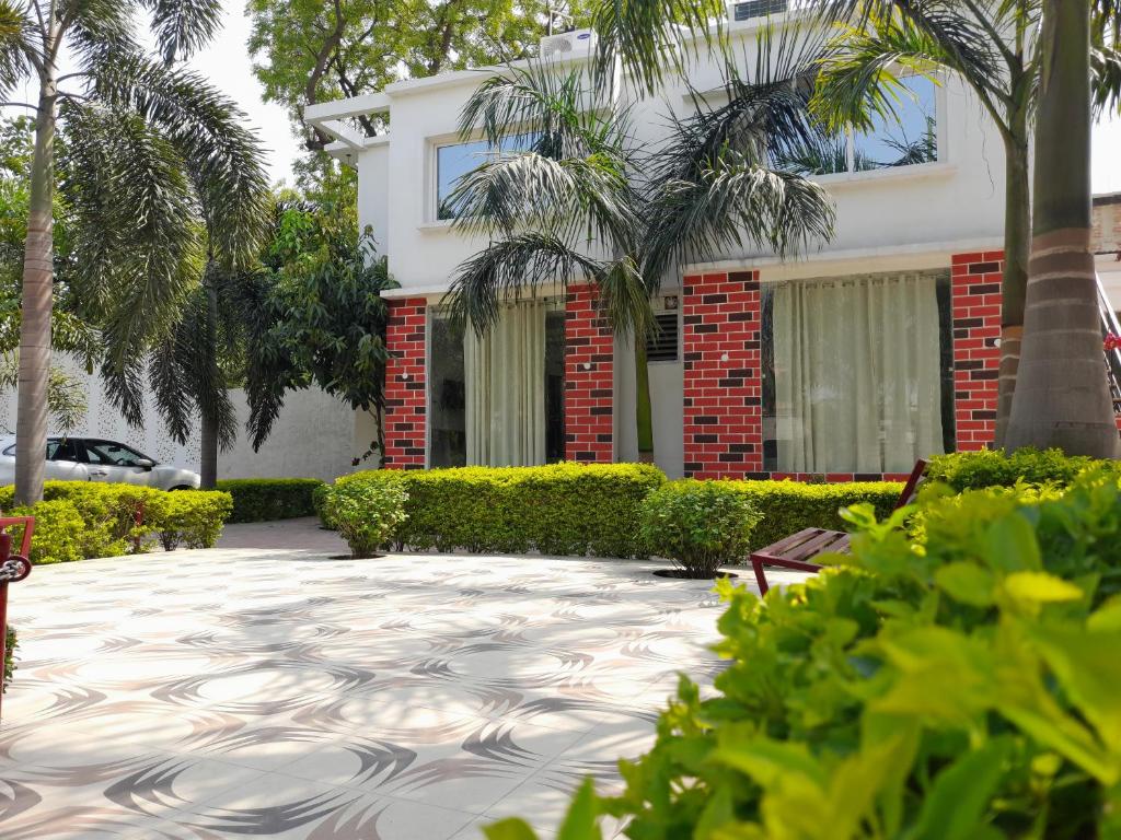 BegusaraiAshoka Resort & Banquets的前面有棕榈树的房子