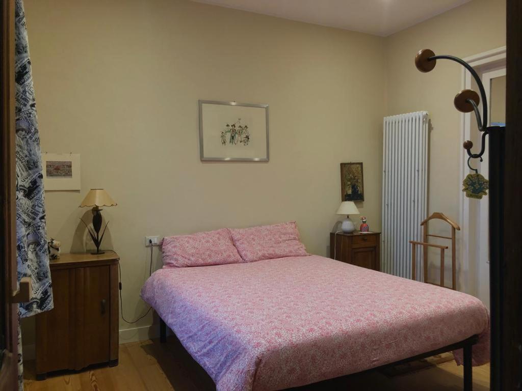 库尼奥casa silvio pellico的一间卧室配有一张带粉色毯子的床