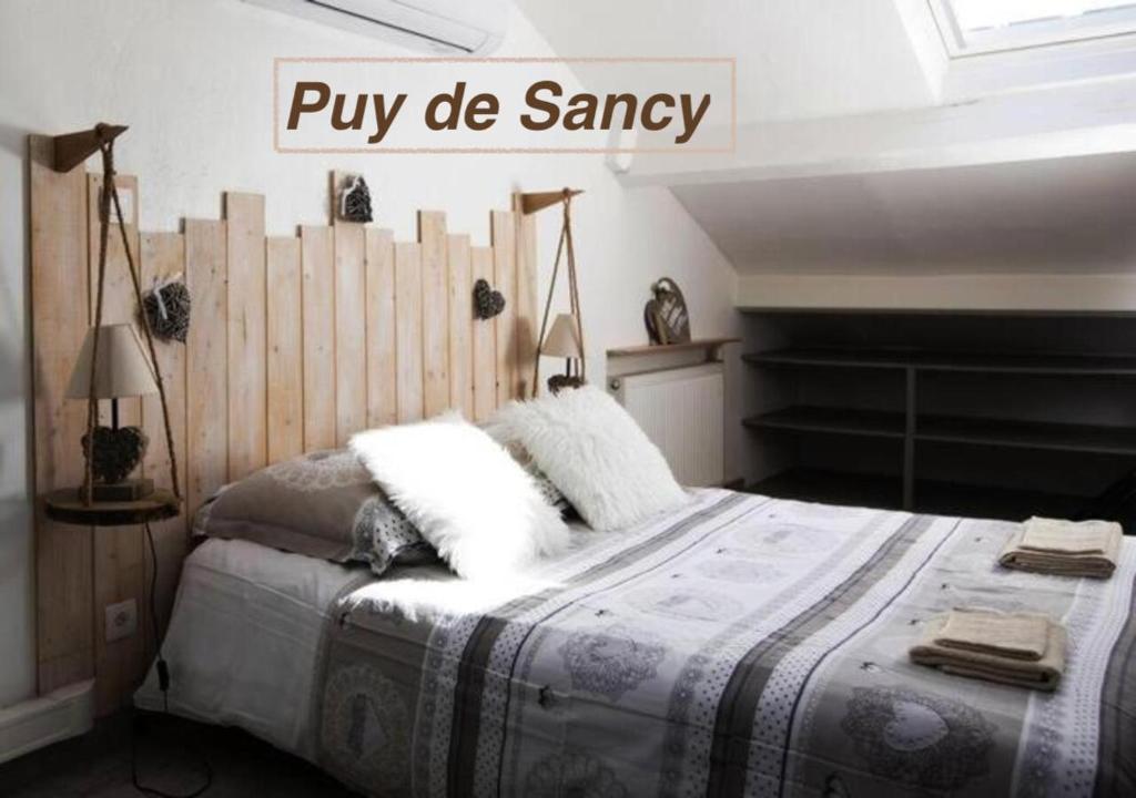 克莱蒙费朗Logements Chaîne des Puys avec garages attenants的一间卧室配有一张大床和木制床头板