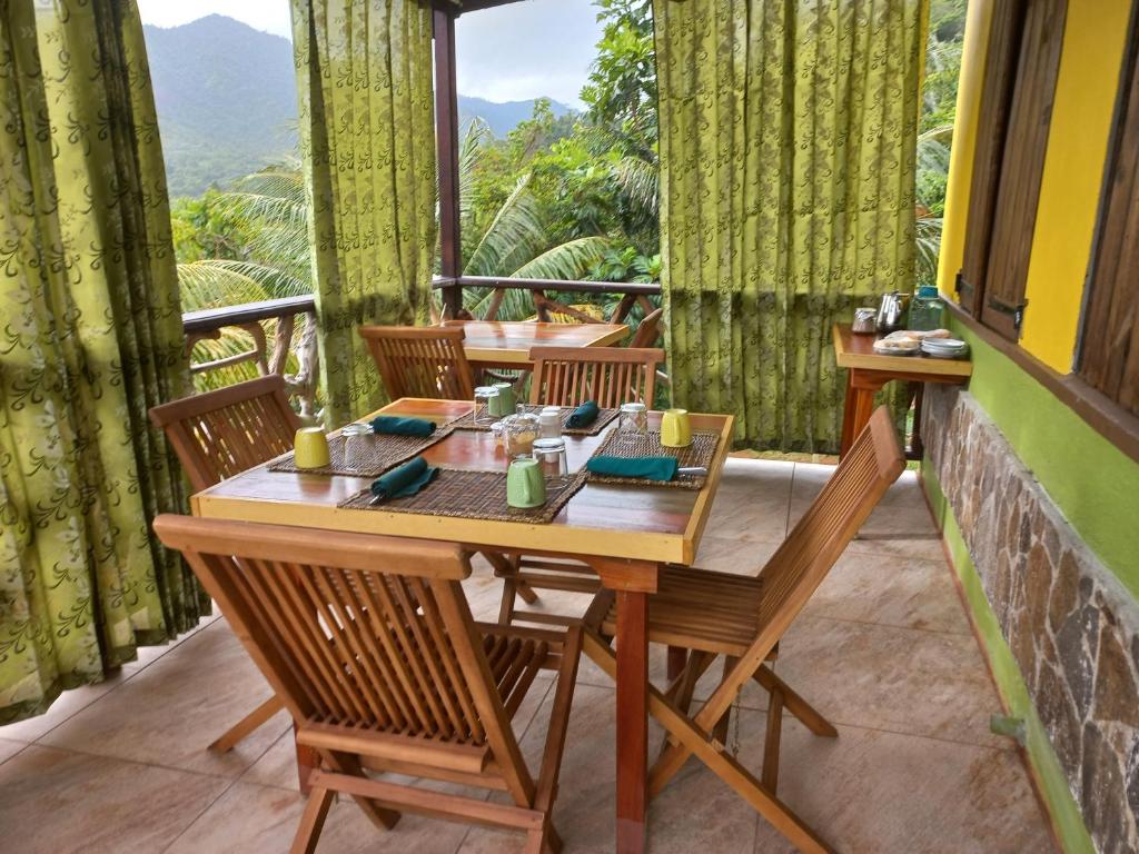 Marigot多米尼加宁静小屋酒店的美景阳台配有桌椅