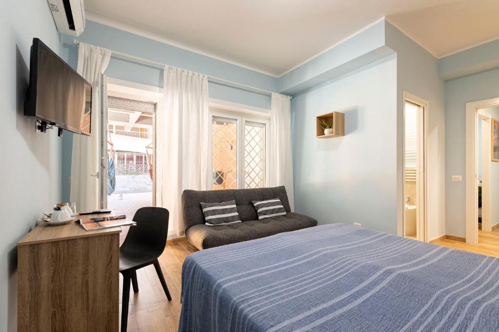 丽都迪奥斯蒂亚RomeCookSea Guesthouse的一间卧室配有一张床、一张沙发和一台电视
