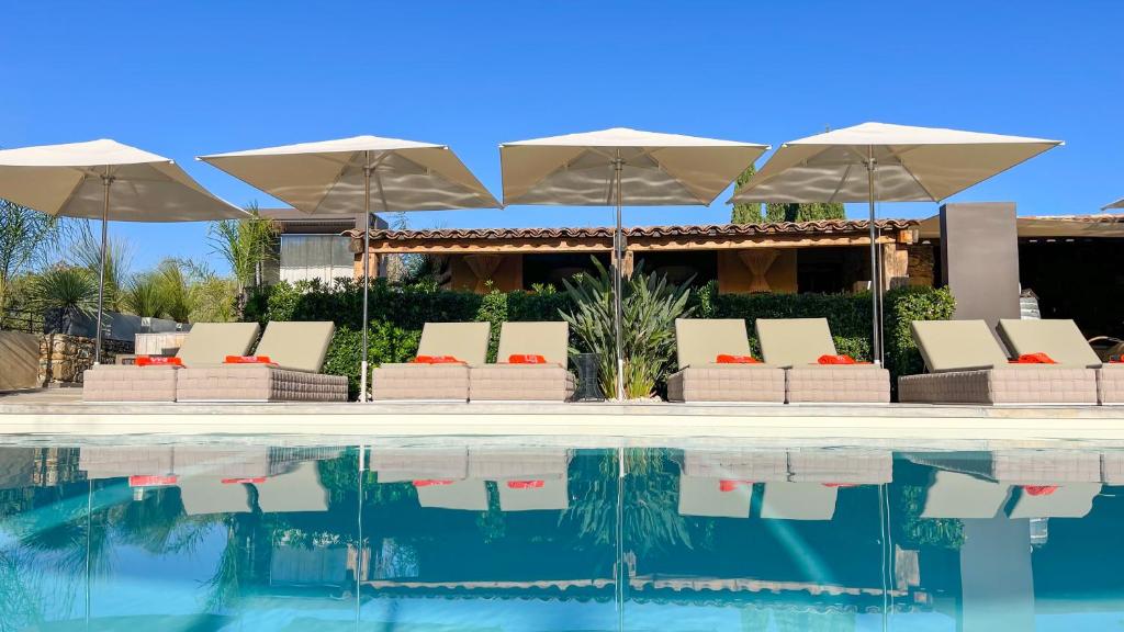 圣弗洛朗Hôtel La Dimora & Spa的房屋旁的游泳池配有遮阳伞和椅子