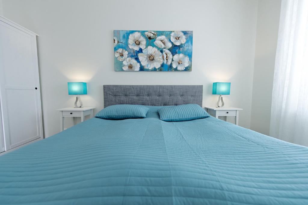 玛丽港联排别墅公寓的一间卧室配有一张带两盏灯的蓝色床。