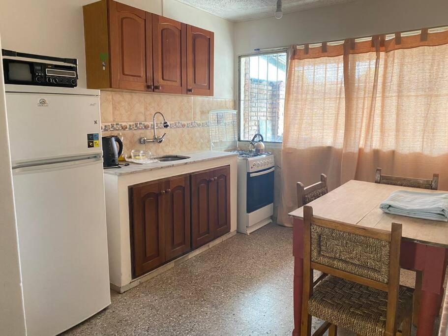 卡梅隆Departamento vivienda completo的厨房配有白色冰箱和桌子