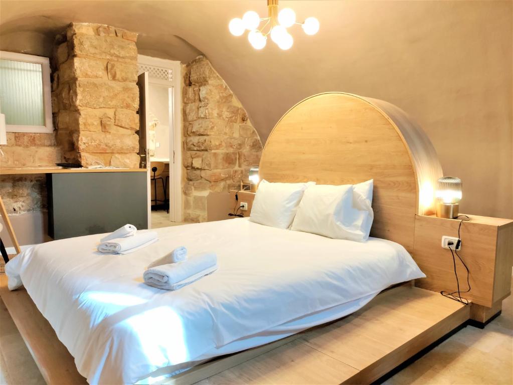 耶路撒冷Mina Boutique的一间卧室配有一张大床和两条毛巾